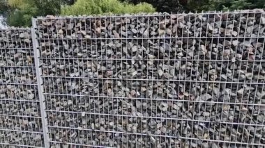 Gabion çitleri çakıl taşları ve kuvars taşlarıyla dolu. Çim, sokak, tel örgüler..