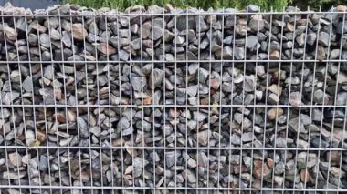 Gabion çitleri çakıl taşları ve kuvars taşlarıyla dolu. Çim, sokak, tel örgüler..