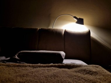 Yastık, tekstil destekli bir yataktır. Bir lambanın akşam ışığı ve sıcak bir ışık. Kapak, yatmadan önce akşam rahatlığı bir kurgu kitabı okuma ritüelidir.