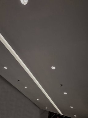 Kemerdeki LED şeritlerle aydınlatılmış bir korniş. Kahverengi ahşap kontrplakla kaplı duvarlar. Işık konileri neşeli bir izlenim bırakır. Büyük bir ünü ve atmosferi olan bir gece kulübü.