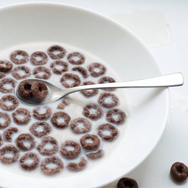 Mısır halkaları, süt ve beyaz zemin üzerine kakao ile kahvaltı.