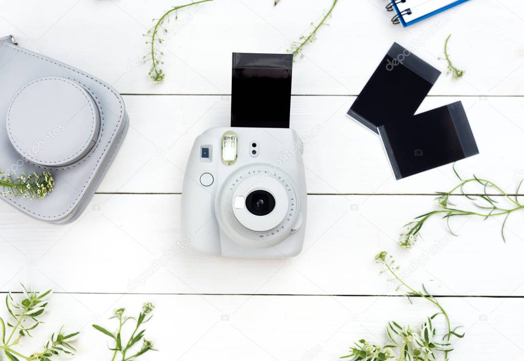 Vintage photo camera on white background with photo cards. Polaroid camera. Instax white camera. Flat lay. Eye bird view