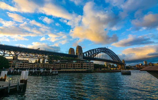 Sunset and evening clouds over Sydney Harbour Bridge as seen from the docks at Circular Quay