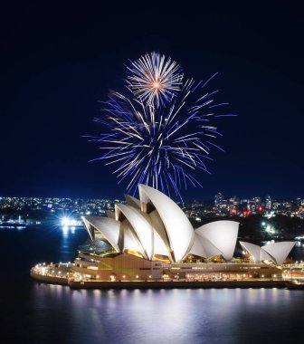 Sydney, Avustralya - 8 Mart 2018 - Sydney Harbor bir muhteşem havai fişek gösterisi altında mavi yansımaları ile Opera Evi parlıyor