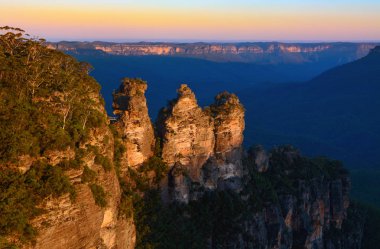 Üç kız kardeş landmark Avustralya Blue Mountains doruklarına günbatımı turuncu parlamayı