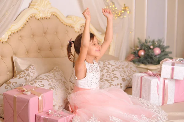 Mädchen Rosenkleid Wachte Mit Weihnachtsgeschenken Auf Dem Bett Auf — Stockfoto