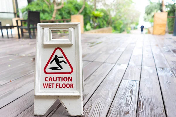 Caution wet floor sign with wooden background