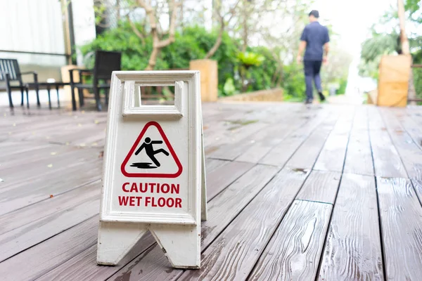 Caution wet floor sign with wooden background