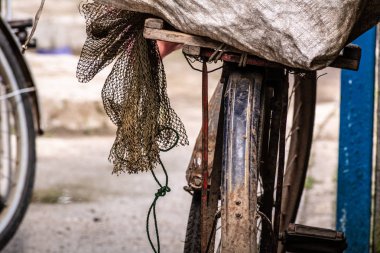 Eski bir bisiklet koltuğunda çamur kaplı Balık ağı