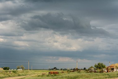 Kasvetli gökyüzünün tarımsal ekipman bir arka plan üzerinde. Kasvetli gök gürültüsü gibi kırsal manzara.