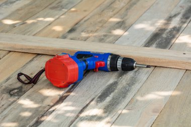 Ahşap masa arka plan üzerinde elektrikli matkap kapatın. Matkap veya tornavida, ahşap üzerinde elektrik akülü el matkap çekiç. Bakım ev concept.