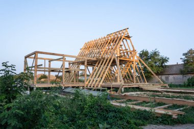 Ahşap çerçeve yapım aşamasında bina konut. Yeni konut inşaat ev çerçeve mavi gökyüzü karşı gün batımında.