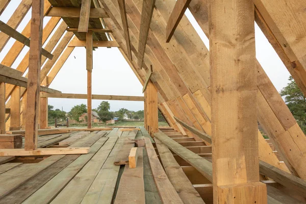 Roof frame structure in wood frame home under construction at sunset, Shagany Lagoon, Ukraine.