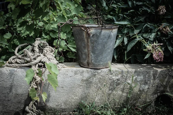 Tali Dengan Seng Ember Terhadap Latar Belakang Kebun Anggur Malam — Stok Foto