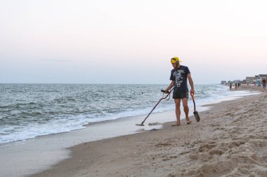 Gün batımı hazine için baktıktan sonra Karadeniz Sahil boyunca hazine avcısı bir metal dedektörü ile yürüyor