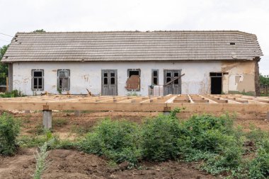 Kazık temel çerçeve ev. Beton ve ahşap evin katında baz yığınları.