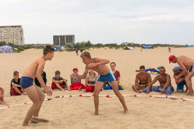 Zatoka, Odessa, Ukrayna - 16 Temmuz 2019: Gün batımında sahilde el ele mücadele