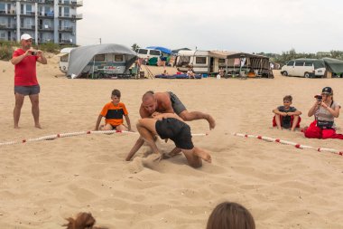 Zatoka, Odessa, Ukrayna - 16 Temmuz 2019: Gün batımında sahilde el ele mücadele