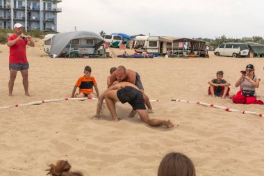 Zatoka, Odessa, Ukrayna - 16 Temmuz 2019: Gün batımında sahilde el ele mücadele