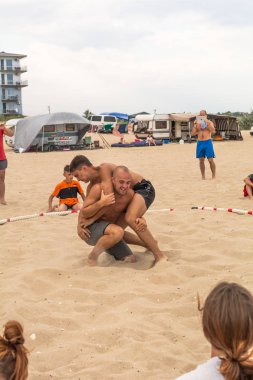 Zatoka, Odessa, Ukrayna - 16 Temmuz 2019: Gün batımında sahilde el ele mücadele