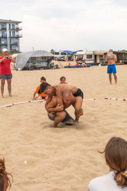 Zatoka, Odessa, Ukrayna - 16 Temmuz 2019: Gün batımında sahilde el ele mücadele