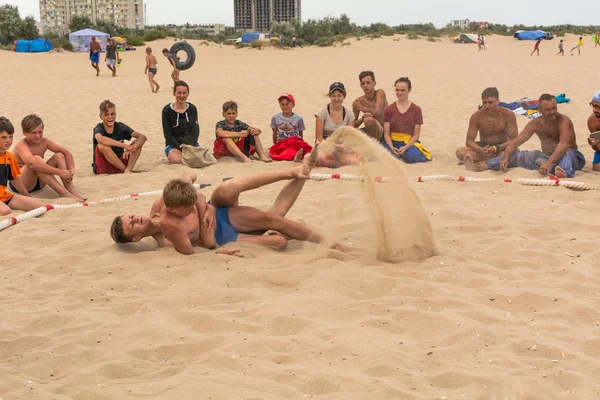 Zatoka, Odessa, Ukrayna - 16 Temmuz 2019: Gün batımında sahilde el ele mücadele