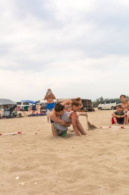 Zatoka, Odessa, Ukrayna - 16 Temmuz 2019: Gün batımında sahilde el ele mücadele