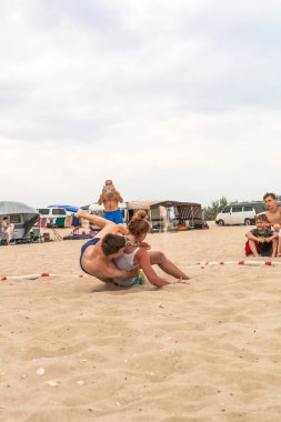 Zatoka, Odessa, Ukrayna - 16 Temmuz 2019: Gün batımında sahilde el ele mücadele