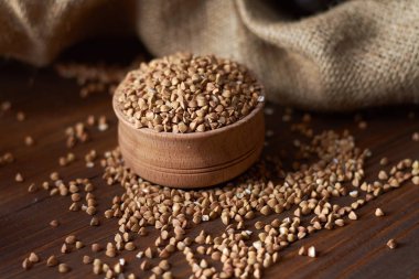 Arka planda bir kase ile ahşap bir kapta buğday Torbalı