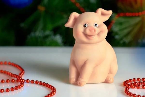 ceramic pig on the background of the Christmas tree and toys