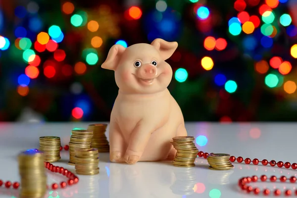 ceramic pig piggy banks with coins on the background of the Christmas tree