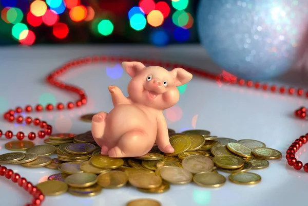 ceramic pig piggy banks with coins on the background of the Christmas tree