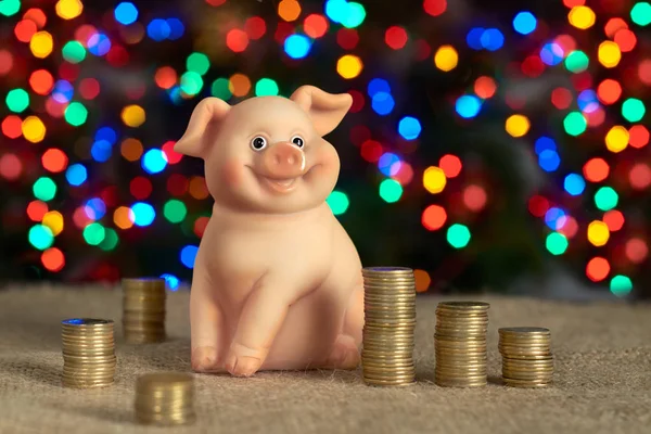 ceramic pig piggy banks with coins on the background of the Christmas tree