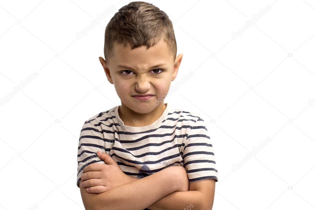 Closeup portrait of an angry boy with his arms folded 