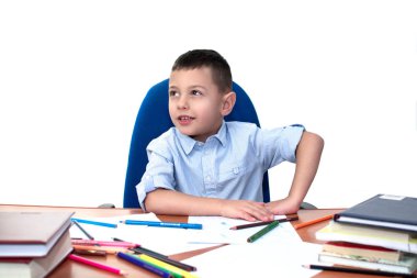 Okul defter ve Kitaplar ile bir masada oturan ve dikkatle üzerinde beyaz bir adam izole yan dolaşırken yaş küçük çocuk