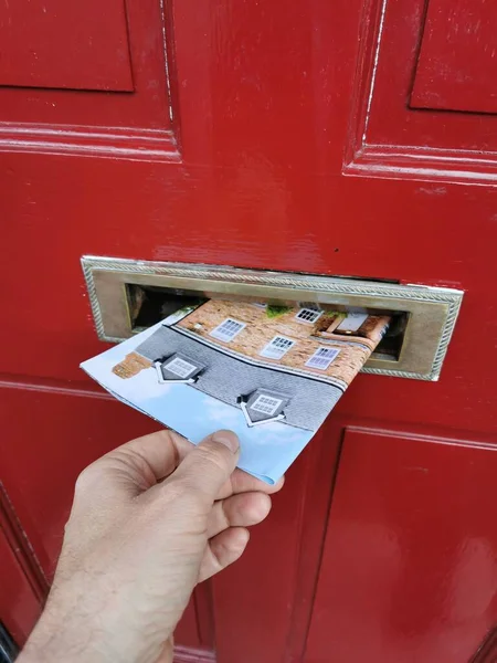 Junk mail being posted through letterbox in the UK