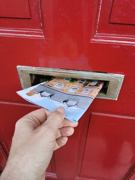 Junk mail being posted through letterbox in the UK