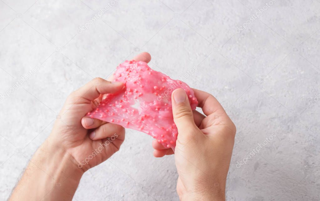 Man playing handmade toy called Slime, experiment scientific method.Games mucus