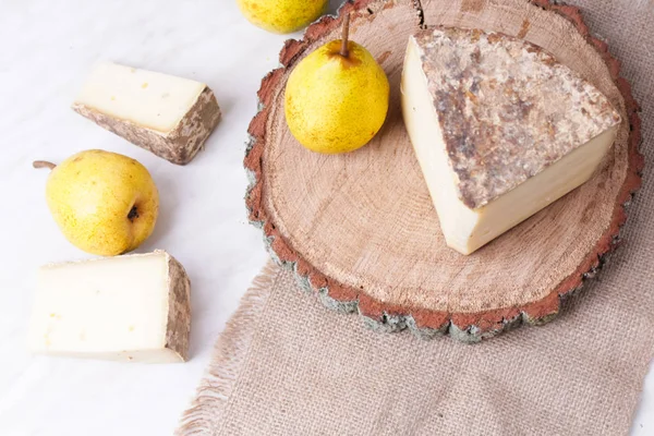 ヤギのチーズと古い素朴な木製の背景 選択と集中の梨 — ストック写真