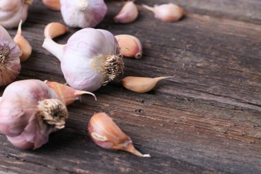 Sarımsak basın, kafaları ve karanfil ahşap arka plan üzerinde kompozisyonu 