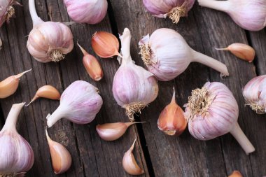 Sarımsak basın, kafaları ve karanfil ahşap arka plan üzerinde kompozisyonu 