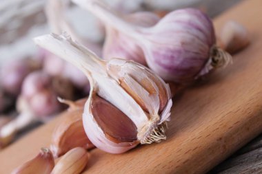 Sarımsak basın, kafaları ve karanfil ahşap arka plan üzerinde kompozisyonu 