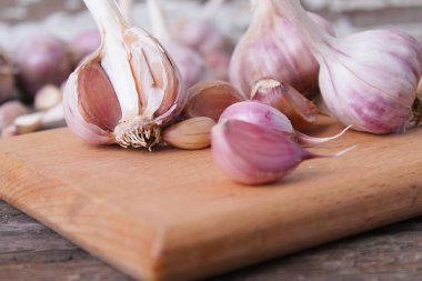 Sarımsak basın, kafaları ve karanfil ahşap arka plan üzerinde kompozisyonu 