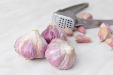 Sarımsak basın, kafaları ve karanfil ahşap arka plan üzerinde kompozisyonu 