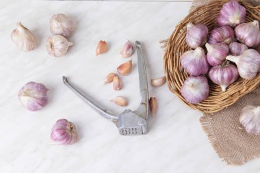 Sarımsak basın, kafaları ve karanfil ahşap arka plan üzerinde kompozisyonu 