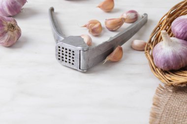 Sarımsak basın, kafaları ve karanfil ahşap arka plan üzerinde kompozisyonu 