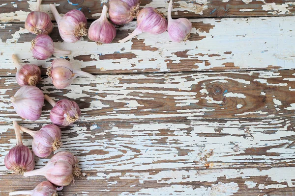 Sarımsak basın, kafaları ve karanfil ahşap arka plan üzerinde kompozisyonu 