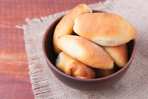 Fresh baked pasties on wooden table