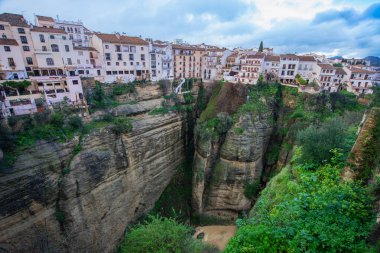 İspanya 'nın Ronda kasabasının dramatik uçurumları derin Guadalevin Nehri geçidine bakar, antik şehri yemyeşil yemyeşil eski ve yeni yerlere ayırır..