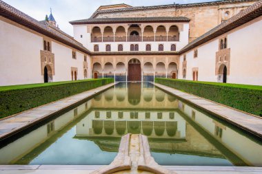 La Alhambra İspanya 'daki sakin Patio de los Arrayanes avlusuna hayranlık duyun, yansıtıcı havuzu ve İslam mimarisini yansıtan zarif kemerleriyle.